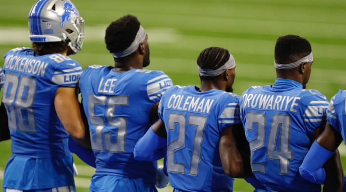 Detroit Lions players stand arm in arm